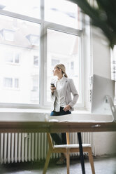 Geschäftsfrau im Büro mit Blick aus dem Fenster - JOSF01057