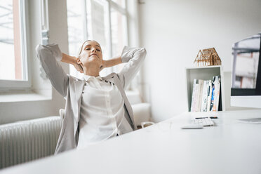 Businesswoman relaxing at desk in her office - JOSF01061