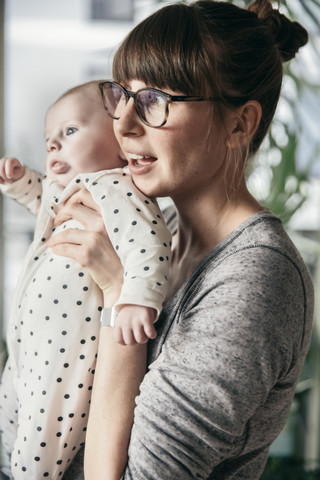 Mutter hält Baby hoch, lizenzfreies Stockfoto
