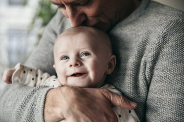 Mature father kissing laughing baby on its head - MFF03600