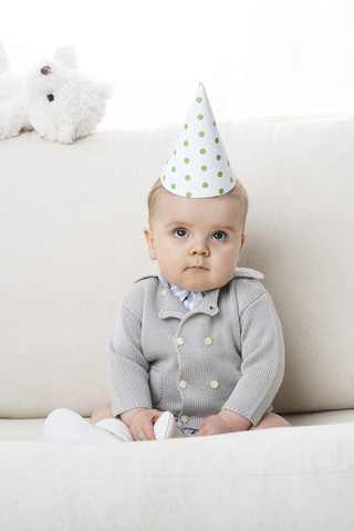 Porträt eines ernsten kleinen Jungen mit Papierhut, lizenzfreies Stockfoto