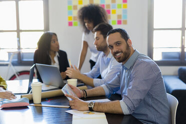 Portrait of smiling businessman during a meeting in office - GIOF02633