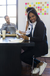 Portrait of smiling businesswoman during a meeting in office - GIOF02634