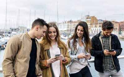 Group of friends sending messages with the smartphone - MGOF03396