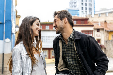 Couple smiling at each other in the city - MGOF03404