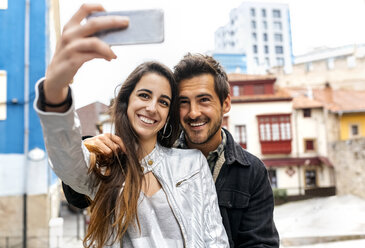 Ein lächelndes Paar macht ein Selfie in der Stadt - MGOF03405
