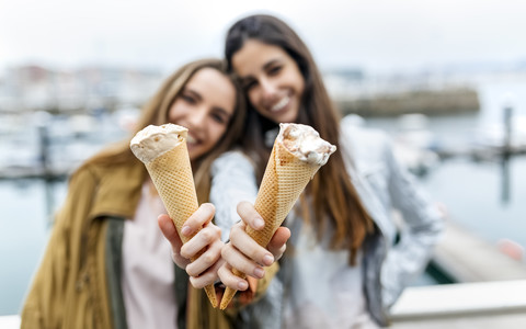 Zwei junge Frauen, die sich mit Eiscreme vergnügen, lizenzfreies Stockfoto