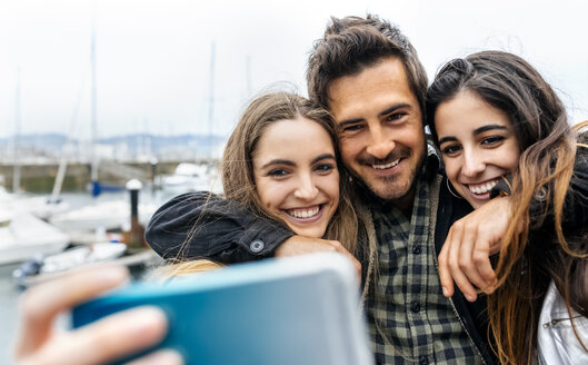 Drei Freunde machen ein Selfie am Yachthafen - MGOF03413