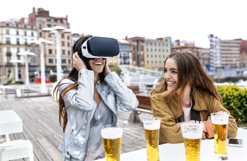 Zwei junge Frauen haben Spaß mit VR-Brillen in der Stadt - MGOF03421