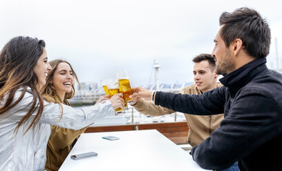 Eine Gruppe von Freunden stößt mit Bier an - MGOF03423