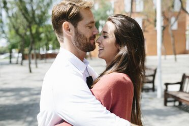 Happy couple kissing and hugging in the street - GIOF02716