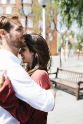 Glückliches Paar, das sich auf der Straße küsst und umarmt - GIOF02717