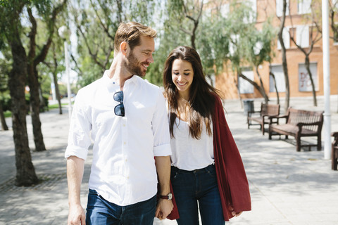 Glückliches Paar auf der Straße, das sich an den Händen hält, lizenzfreies Stockfoto