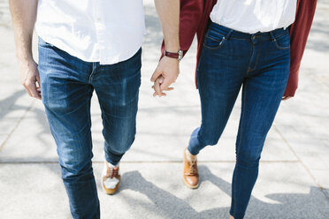 Glückliches Paar, das auf der Straße spazieren geht, Hände haltend, niedriger Ausschnitt - GIOF02722