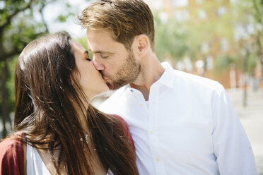 Glückliches Paar, das sich auf der Straße küsst und umarmt - GIOF02724