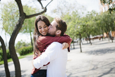 Happy couple kissing and hugging in the street - GIOF02725