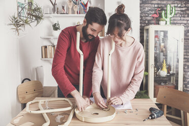 Young couple assembling flat-pack stool at home - RTBF00889