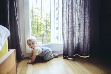 Der kleine Junge krabbelt auf dem Boden im Schlafzimmer - MFF03639