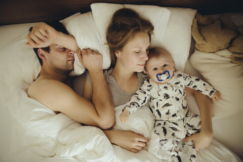 Mutter, Vater und kleiner Junge kuscheln im Bett - MFF03643