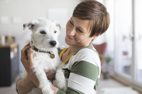 Frau mit ihrem Hund zu Hause, lizenzfreies Stockfoto