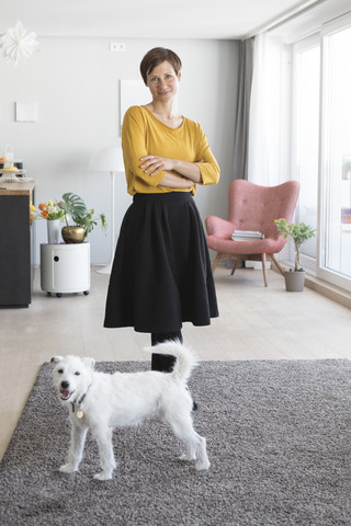 Porträt einer Frau und ihres Hundes im Wohnzimmer, lizenzfreies Stockfoto