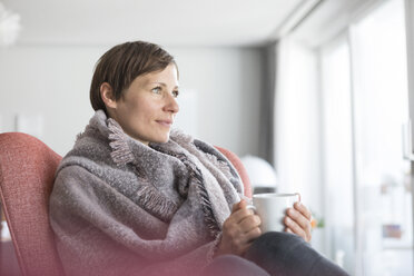 Porträt einer Frau, die sich mit einer Tasse Kaffee zu Hause entspannt - RBF05721