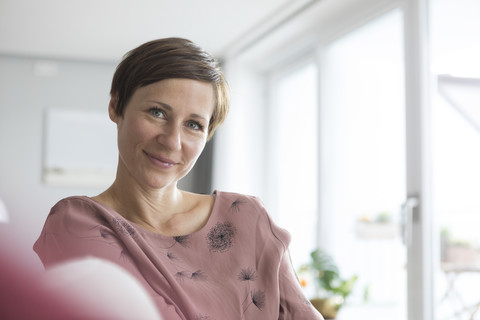 Portrait of smiling woman at home stock photo