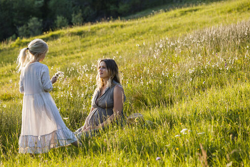 Pregnant mother and daughter on a meadow - TCF05431