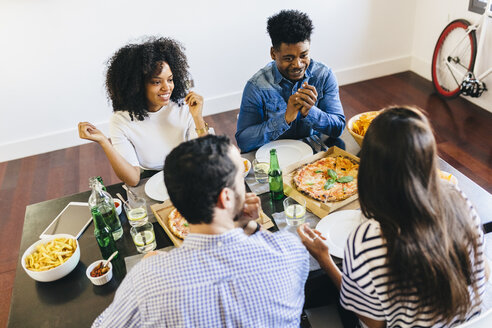 Eine Gruppe von Freunden isst eine Pizza zu Hause - GIOF02737