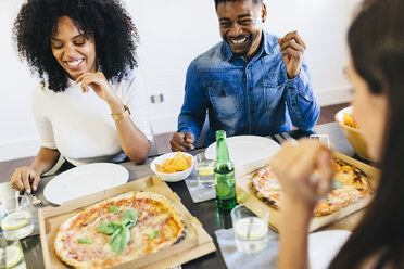 Eine Gruppe von Freunden isst eine Pizza zu Hause - GIOF02738