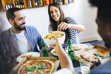 Happy friends having French fries and pizza at home - GIOF02751