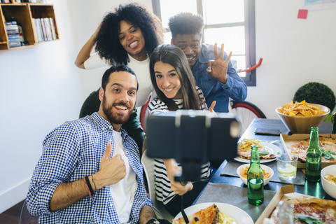 Gruppe von Freunden posiert für ein Selfie am Esstisch zu Hause, lizenzfreies Stockfoto