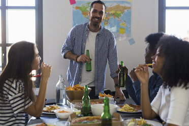 Eine Gruppe von Freunden trifft sich bei Bier und Fast Food zu Hause - GIOF02770