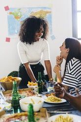 Two happy young women at dining table - GIOF02771