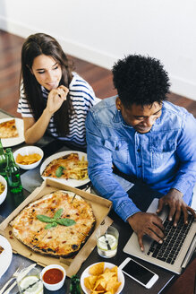 Junger Mann mit Laptop am Esstisch - GIOF02775