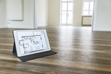 Tablet with floor plan on wooden floor - UUF10827