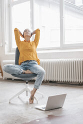 Yung woman sitting in her new flat with a laptop - JOSF01091