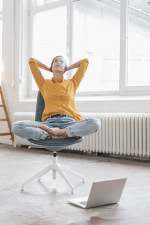 Yung woman sitting in her new flat with a laptop - JOSF01092