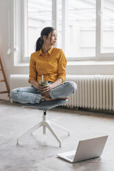 Yung woman sitting in her new flat with a laptop - JOSF01097