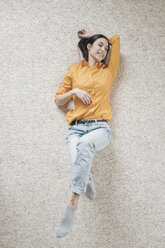 Young woman relaxing on carpet - JOSF01100