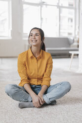 Young woman sitting on floor, smiling - JOSF01104