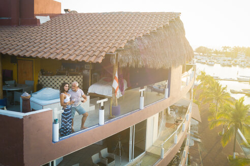 View at penthouse terrace with old man and younger woman enjoying the sunset in Nuevo Vallarta, Nayarit, Mexico - ABAF02163