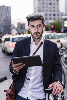 Junger Mann in der Stadt mit Tablet - UUF10855