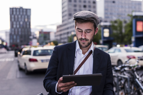 Junger Mann in der Stadt mit Tablet, lizenzfreies Stockfoto