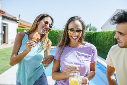 Glückliche Freunde mit Getränk und Wassermelone am Pool - KIJF01508