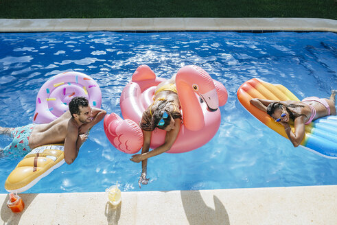 Happy friends on floats in swimming pool - KIJF01536