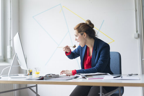 Businesswoman eating lunch in office - JOSF01129