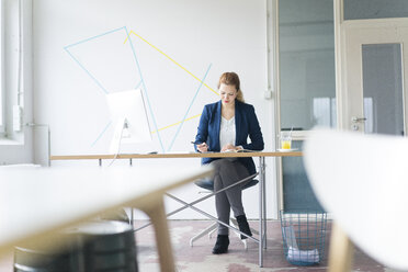 Geschäftsfrau bei der Arbeit am Schreibtisch in ihrem Büro - JOSF01149