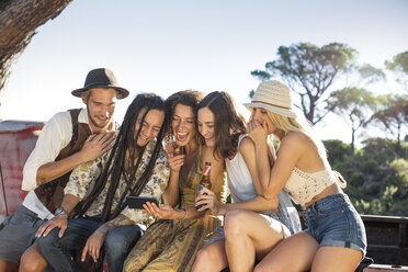 Happy young people outside pick up truck sharing cell phone - ZEF13902