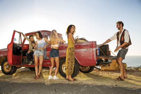 Fröhliche junge Leute vor einem Pick-up-Truck an der Küste - ZEF13911